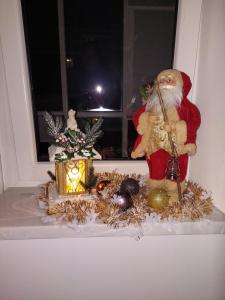 a santa clause sitting on a window sill with decorations at Apartament Vip Chirie in Chişinău