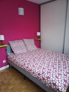 um quarto com uma cama com uma parede rosa em Charmant T3 Gap Sud em Gap