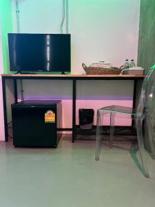 biurko z telewizorem i krzesłem pod nim w obiekcie JAI bed and cafe w mieście Chiang Mai