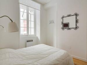 Dormitorio blanco con cama y espejo en la pared en Appartement Cauterets, 3 pièces, 6 personnes - FR-1-401-112, en Cauterets