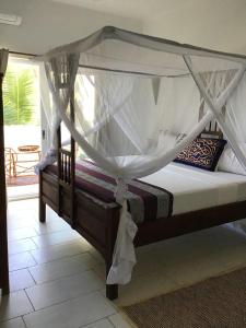 a bed with a canopy in a room at Nakupenda Malaika Flat in Pwani Mchangani