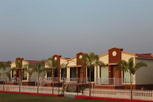 a row of houses with palm trees and a fence at Flamingo Club and Resort Una 3 Km Away from Diu Check Post in Diu