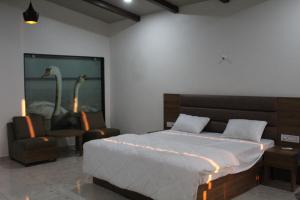 a bedroom with a bed and a room with two swans on the wall at Flamingo Club and Resort Una 3 Km Away from Diu Check Post in Diu