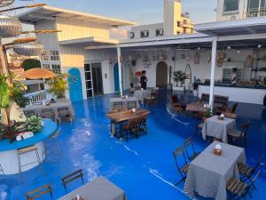 a restaurant with blue flooring and tables and chairs at Jailoy Bed - Cafe & Rooftop in Chiang Mai