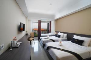 a hotel room with two beds and a television at Brits Hotel Legian in Seminyak