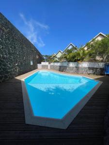 una grande piscina blu seduta accanto a un muro di L'exotique a Saint-Leu