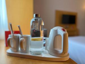 a tray with a coffee maker and cups on a table at Ibis One Central - World Trade Centre Dubai in Dubai