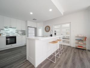 a kitchen with white cabinets and a white counter top at New Home~close to Airport & Swan Valley inc B/fast 1st Morning~ in Perth