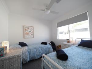 een slaapkamer met 2 bedden en een raam bij New Home~close to Airport & Swan Valley inc B/fast 1st Morning~ in Perth