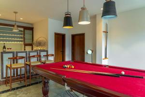 a red pool table in a room with chairs at Jolly Chalet in Rāmgarh