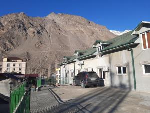 a van parked in a parking lot in front of a mountain at Solim in Khorog