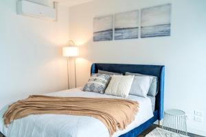 1 dormitorio con 1 cama con cabecero azul en Your home on Glover St Sth Melbourne (With Parking) en Melbourne