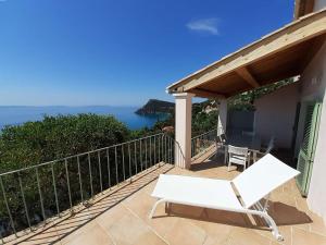 a patio with a white chair and a view of the ocean at Maison Rayol-Canadel-sur-Mer, 5 pièces, 9 personnes - FR-1-308-142 in Rayol-Canadel-sur-Mer