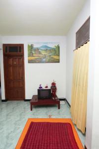 a room with a door and a red rug at Kost&Guesthouse Tirza in Banyuwangi