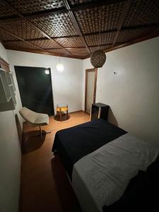 1 dormitorio con 1 cama, 1 silla y 1 pizarra en Hotel Casa do Visconde, en Manaus