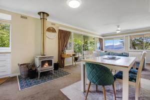 a living room with a table and a fireplace at Wandi Bright View in Wandiligong