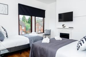 two beds in a room with a tv and a fireplace at Free Parking - Large House - Contractor - Leisure in Birmingham