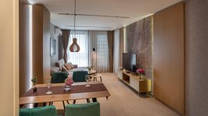 un soggiorno con divano, tavolo e TV di City Park Inn Apartment Cortona a Plovdiv