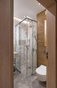 a bathroom with a glass shower with a toilet at City Park Inn Apartment Cortona in Plovdiv