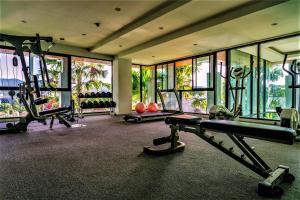 a gym with treadmills and machines in a room with windows at Patong - The Unity Seaview & Mountain Residence in Patong Beach