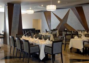 a dining room with tables and chairs and chandeliers at West Inn Hotel Faisalabad in Faisalabad