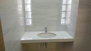 a white sink in a bathroom with a window at Escotel Villa Marga in Tabanan +4 photos