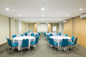 una sala de conferencias con mesas blancas y sillas azules en Hotel Citradream Cirebon en Cirebon