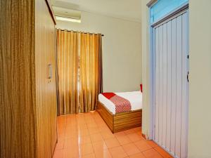 niewielka sypialnia z łóżkiem i oknem w obiekcie OYO Life 91989 K24 Residence Syariah w mieście Palembang