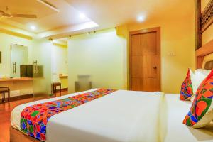 a bedroom with a large bed and a bathroom at FabHotel Keerthi's Anupama Governor Peta in Vijayawāda