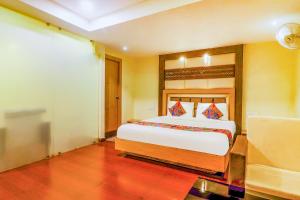 een slaapkamer met een groot bed in een kamer bij FabHotel Keerthi's Anupama Governor Peta in Vijayawāda