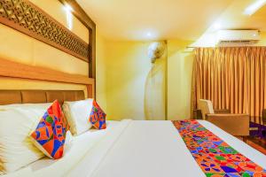 a hotel room with a bed and a room with at FabHotel Keerthi's Anupama Governor Peta in Vijayawāda