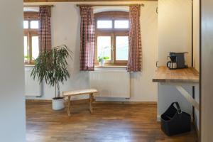 una stanza con tavolo, pianta e finestre di Ruhe-haus a Grafenau