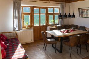 un soggiorno con tavolo e sedie in legno di Ruhe-haus a Grafenau