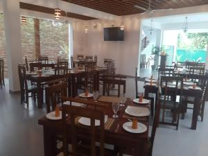 un comedor con mesas y sillas en un restaurante en Eden Grand en Dambulla