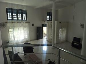 uma pessoa sentada num chão de vidro num quarto em 4Seasons Holiday Home em Ratnapura