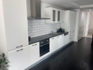 a kitchen with white cabinets and a black stove at Mount Views in Mount Maunganui