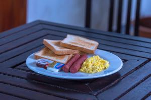 a plate of breakfast food with sausage eggs and toast at Black Pearl Himandhoo in Himandhoo 