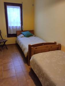 een slaapkamer met 2 bedden en een raam bij Casa de camp prop de la Costa Brava in Romanyá de la Selva