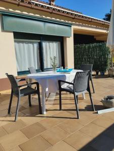 een witte tafel en stoelen op een patio bij Casa de camp prop de la Costa Brava in Romanyá de la Selva