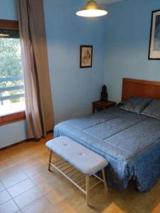 een slaapkamer met een blauw bed, een stoel en een raam bij Casa de camp prop de la Costa Brava in Romanyá de la Selva