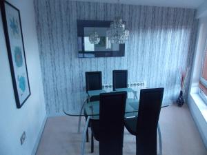 uma sala de jantar com uma mesa de vidro e cadeiras em Waterside Apartment em Lancaster