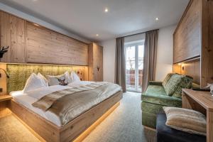 ein Schlafzimmer mit einem großen Bett und einem grünen Sofa in der Unterkunft Jugendgästehaus Gruber in Großarl
