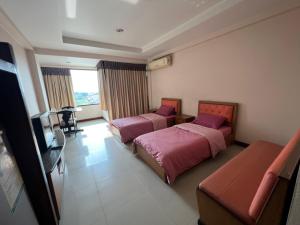 a hotel room with two beds and a television at THE POPULAR PLACE in Ban Khlong Thewa