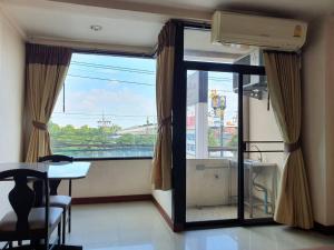 a room with a large window and a table and a table and chairs at THE POPULAR PLACE in Ban Khlong Thewa