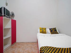 a living room with a couch and a tv at SPOT ON 91993 Pondok Hs Padalarang Syariah in Padalarang