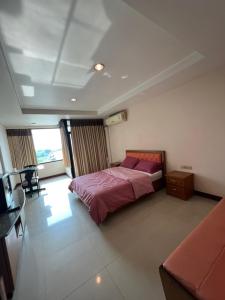 a bedroom with a bed with a purple bedspread at THE POPULAR PLACE in Ban Khlong Thewa