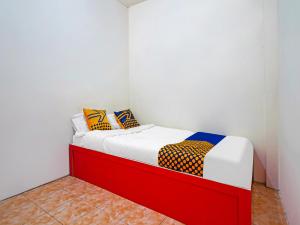 niewielka sypialnia z łóżkiem z czerwoną ramą w obiekcie SPOT ON 91993 Pondok Hs Padalarang Syariah w mieście Padalarang