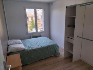 a small bedroom with a bed and a window at Très bel appartement proche parc des expositions et aéroport Roissy CDG in Villepinte