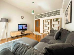 uma sala de estar com um sofá e uma televisão de ecrã plano em Downtown Flat near Center with 24h Self Check-In em Tirana