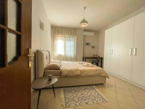um quarto com uma cama, uma mesa e uma porta em Downtown Flat near Center with 24h Self Check-In em Tirana